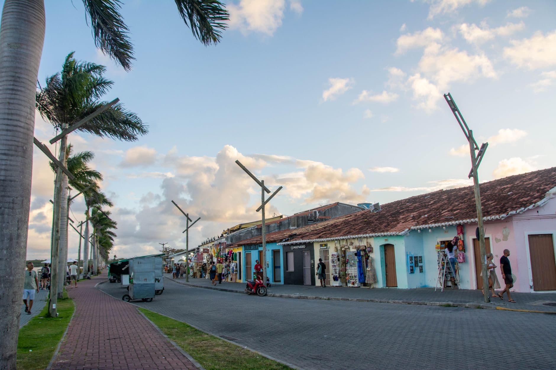 Charming street scene with colorful buildings and palm trees in Porto Seguro, Bahia, Brazil at sunset.