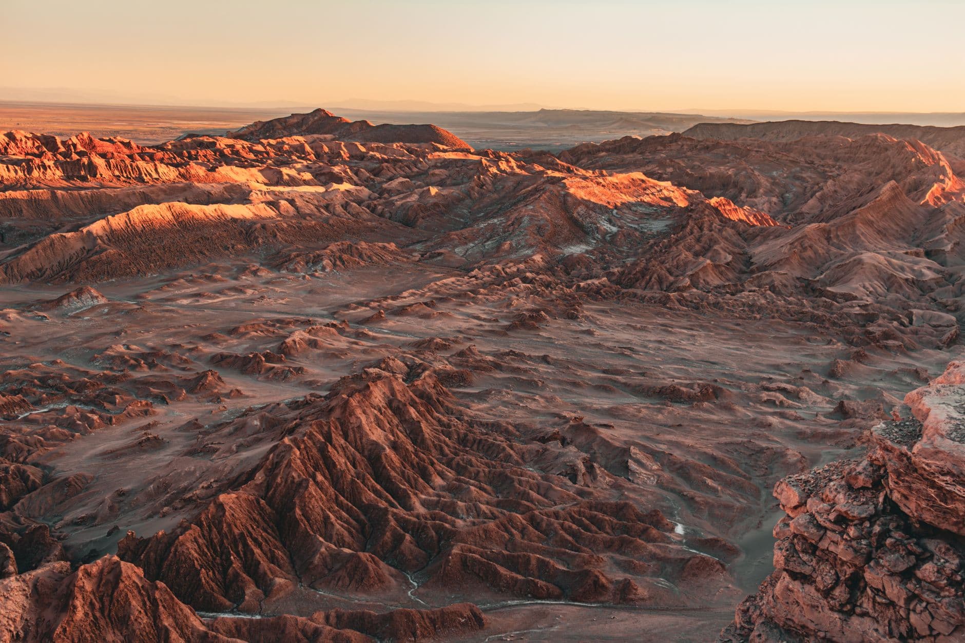 A stunning aerial view of the arid landscape in Valle de la Luna at sunset, Atacama Desert.