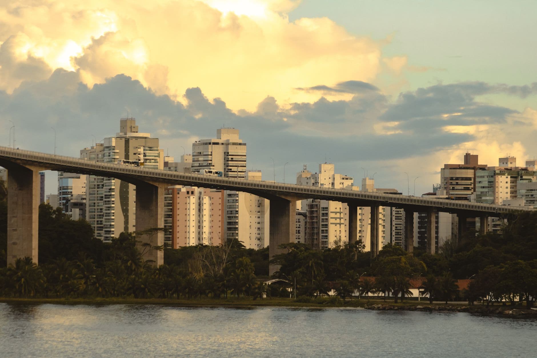 Scenic view of Recife skyline with elevated bridge and cloudy sunset sky.