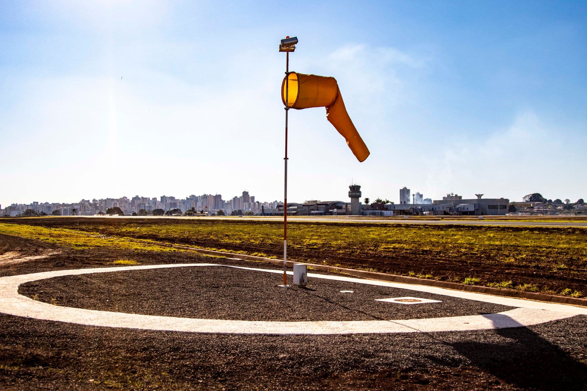 View of a windsock and control tower at Londrina airport highlighting aviation and communication.