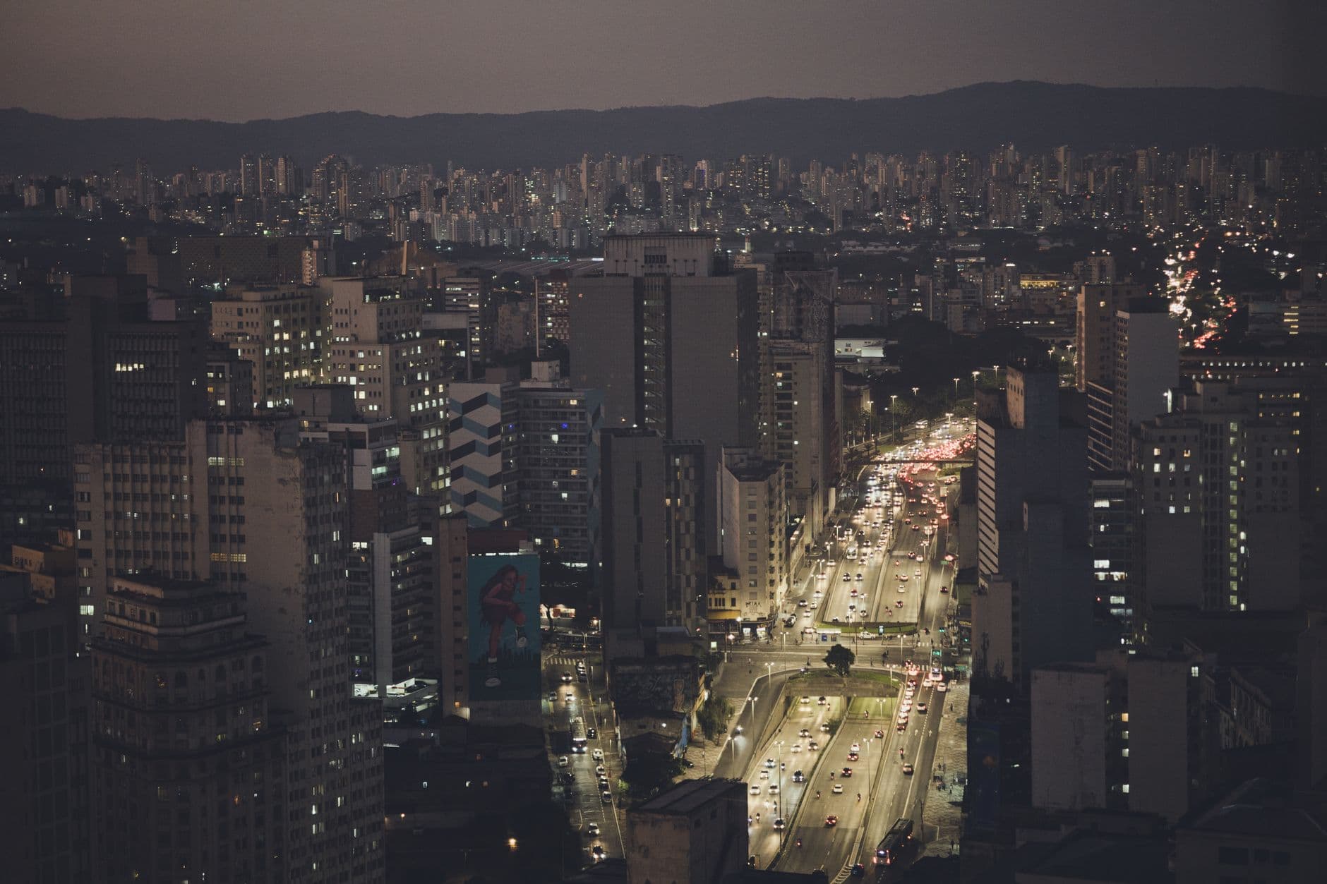 Aerial view of São Paulo's downtown with illuminated streets and skyscrapers at night.