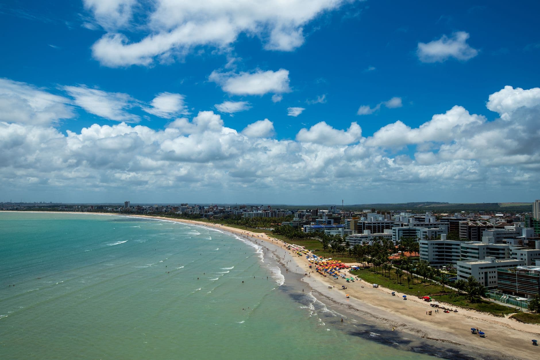 Stunning aerial view of Cabo Branco Beach in João Pessoa, Brazil featuring urban coastline and vibrant waters.