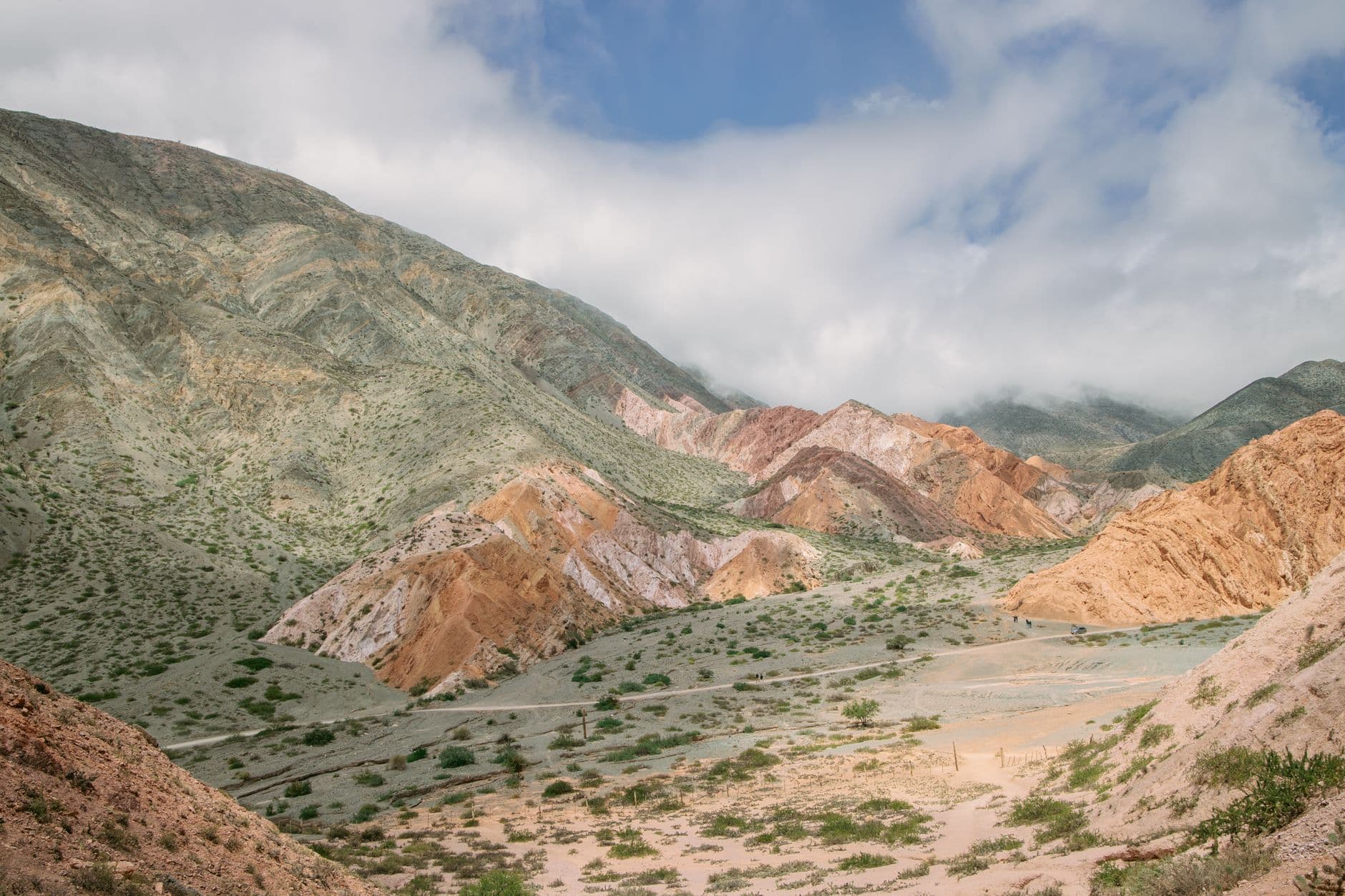 Stunning view of Purmamarca's vibrant hills under a partly cloudy sky in Argentina.