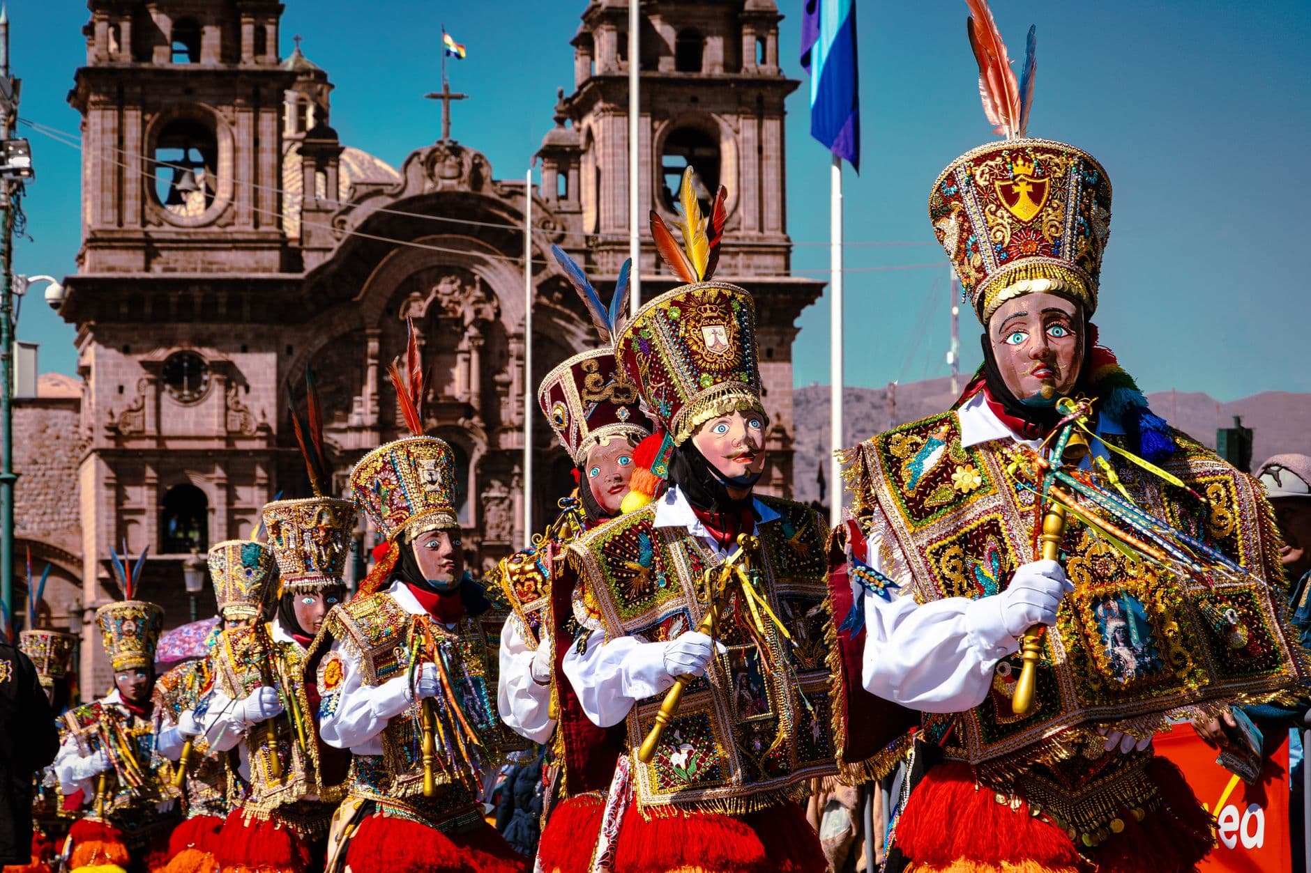Colorful parade with Andean dancers in traditional attire during a festival in Cusco, Peru.
