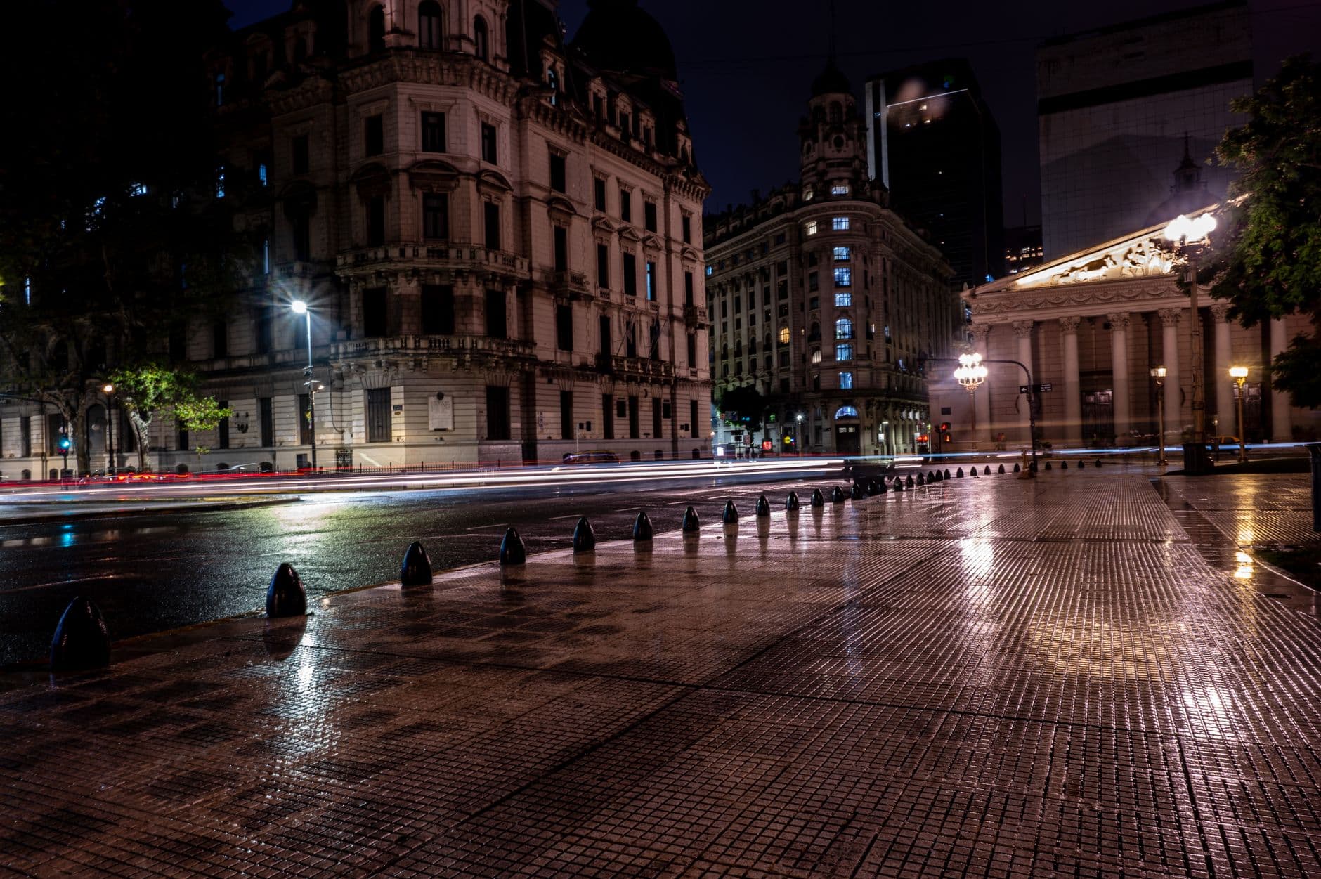 A rainy night view of historic buildings and wet streets in Buenos Aires, Argentina.