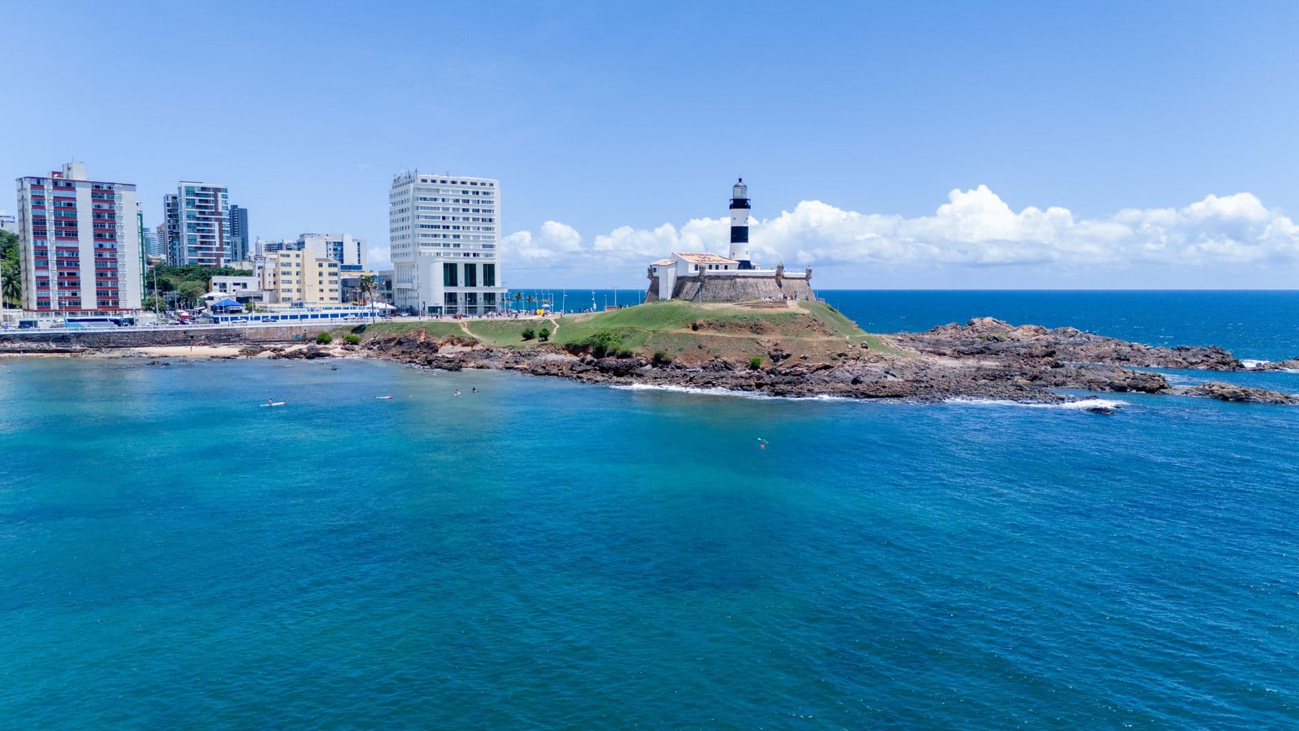 Aerial view of Barra Lighthouse and coastal skyline in sunny Salvador, Brazil.